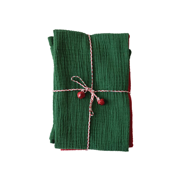 Green fabric wrapped with pink string and red heart decorations on a white background