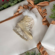 Oatmeal ice skate ornament on white batting. 