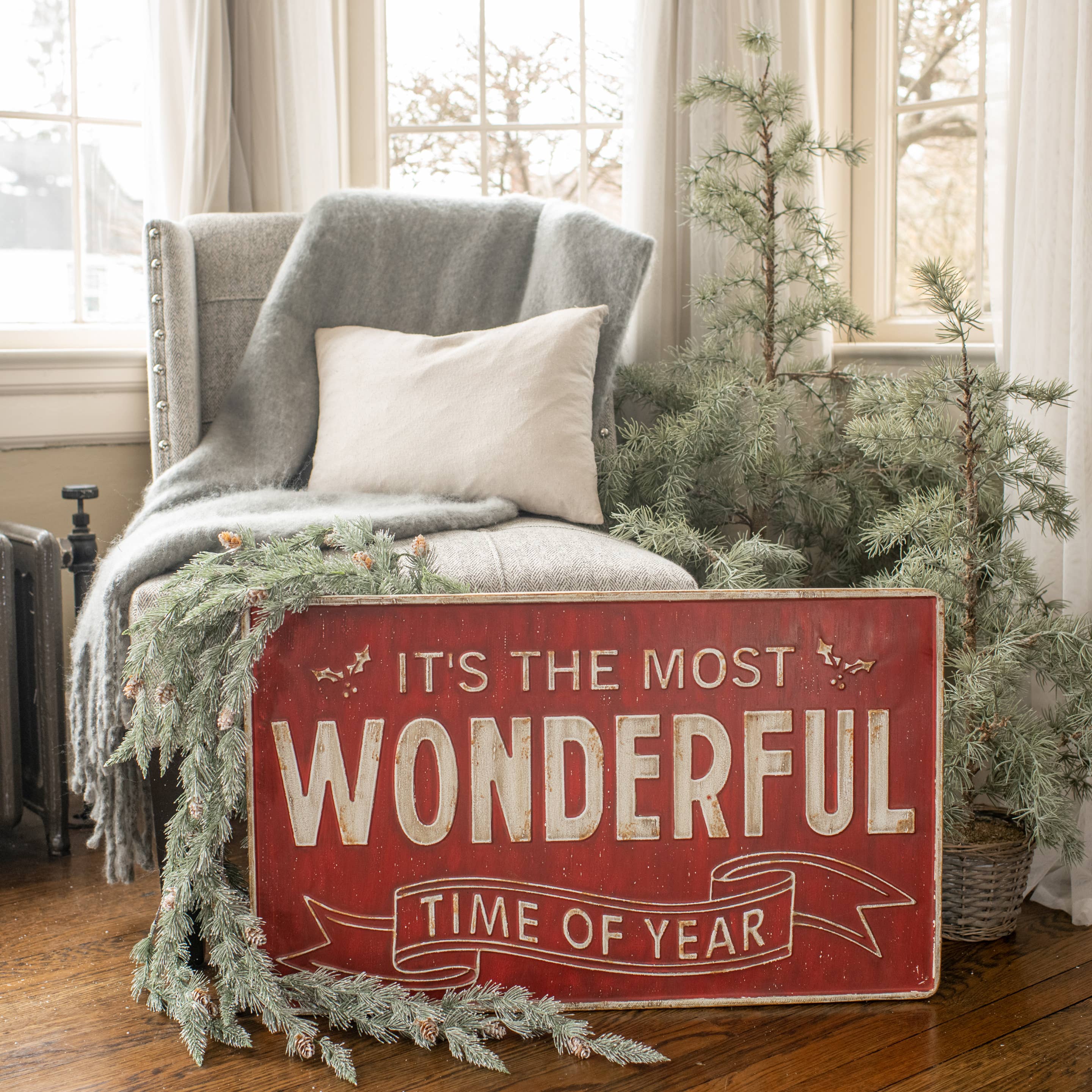 Cozy living room with a chair, blanket, and Christmas sign in a home setting.