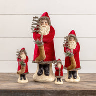 Set of Santa Claus figurines with decorative elements on a wooden surface.