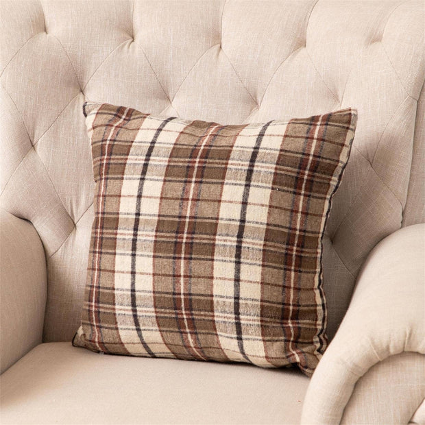 Plaid pillow on a beige tufted sofa