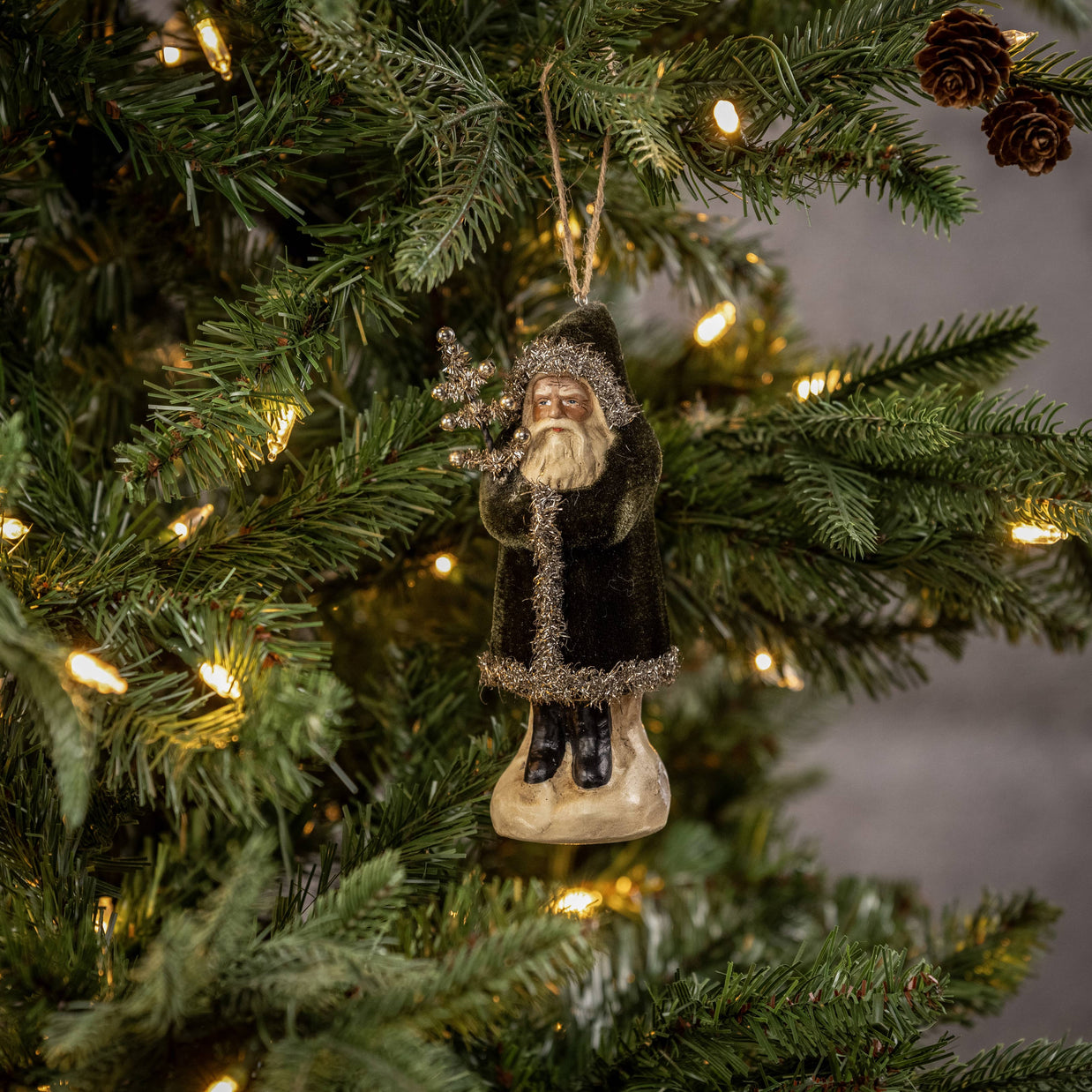 Decorative Christmas ornament of a bearded figure on a lit Christmas tree.