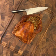 Roasted turkey on a wooden cutting board with a knife