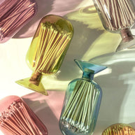 Colorful glass match holders with matches on a light background