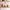 Three ceramic mugs on a wooden shelf against a tiled wall.