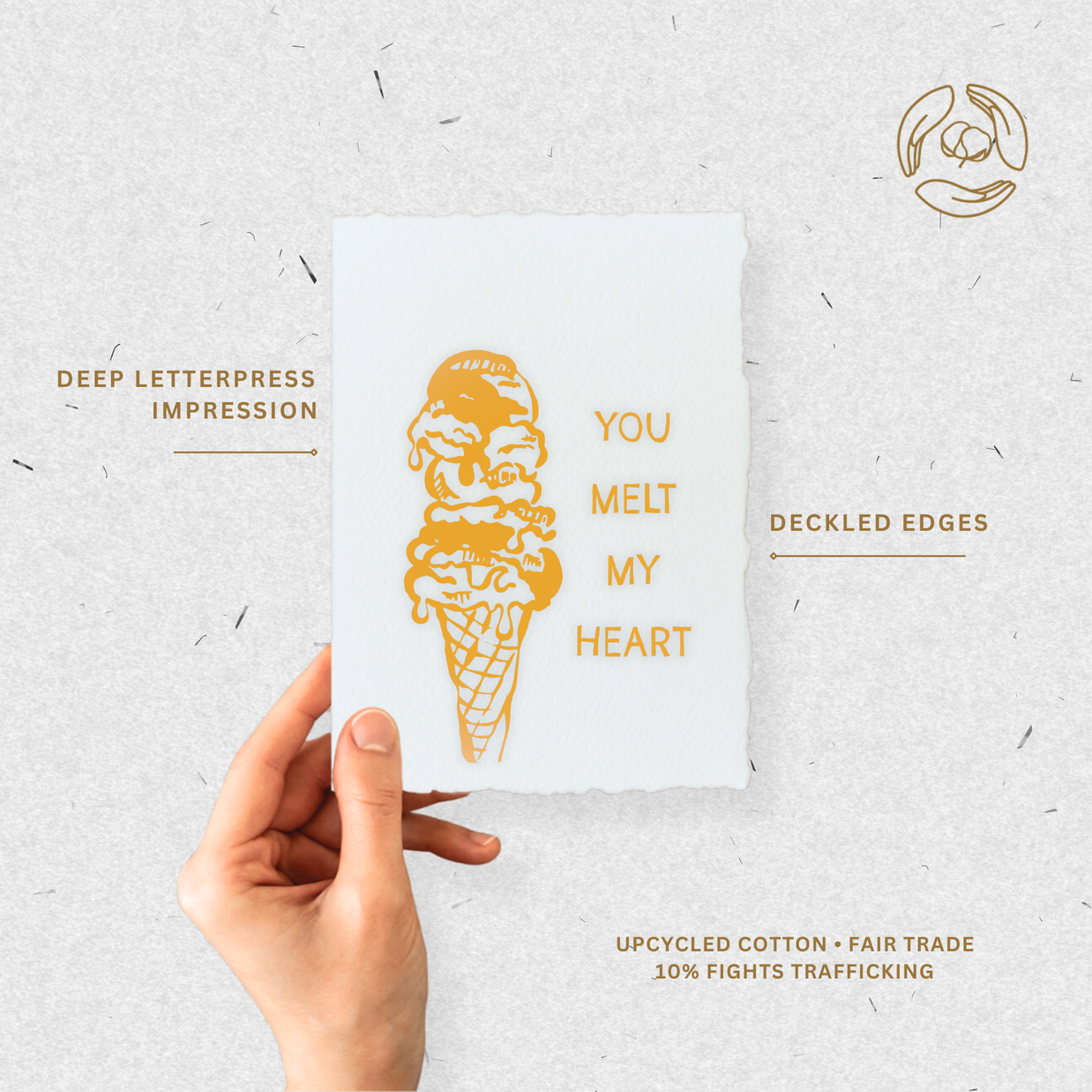 Hand holding a card with a gold ice cream cone illustration and text on a light gray background