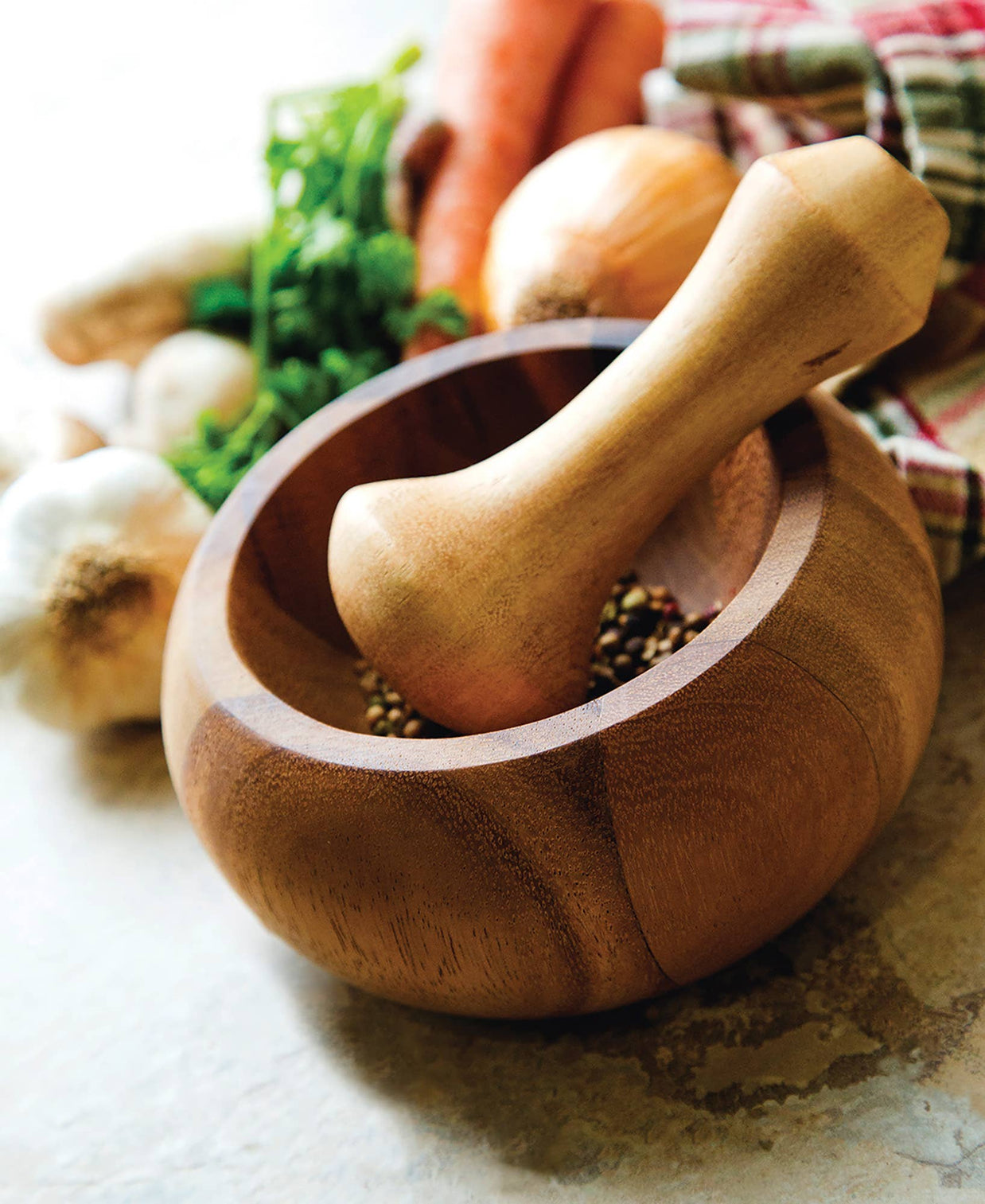 Wooden mortar and pestle with ingredients on a kitchen counter