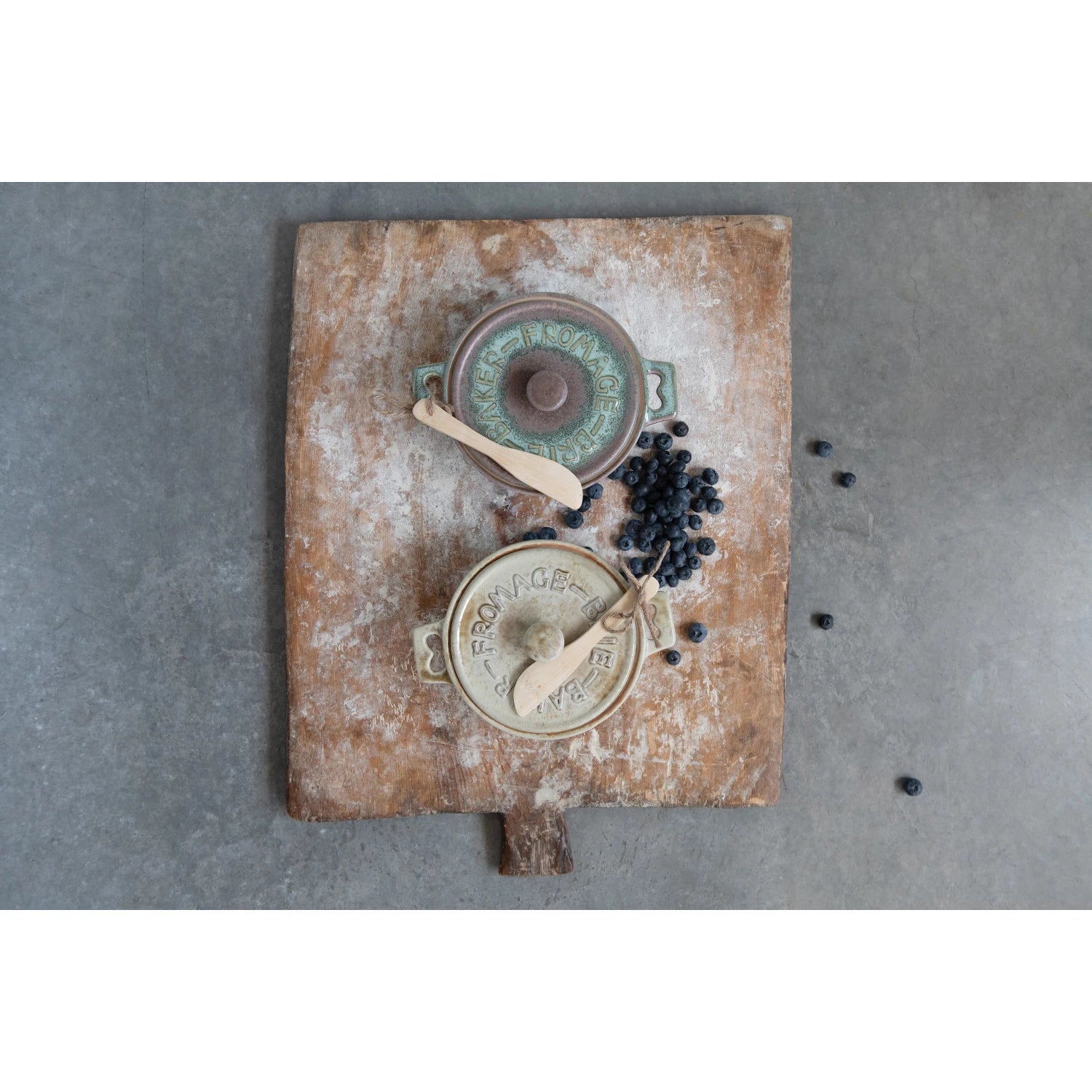 Vintage-style kitchen scene with ceramic pots and wooden utensils on a textured surface