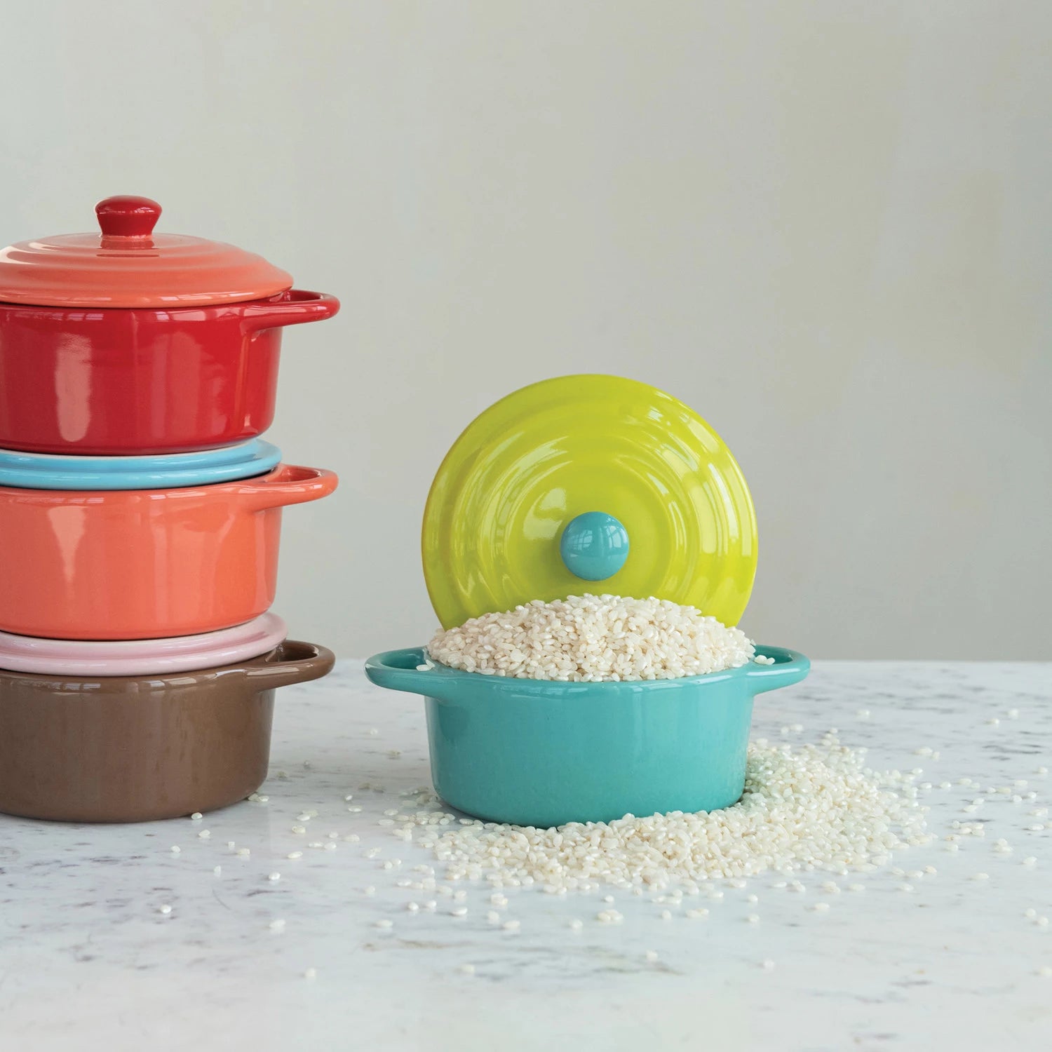 Colorful stackable containers with lids on a light surface