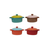 Four colorful mini casserole dishes with lids on a white background