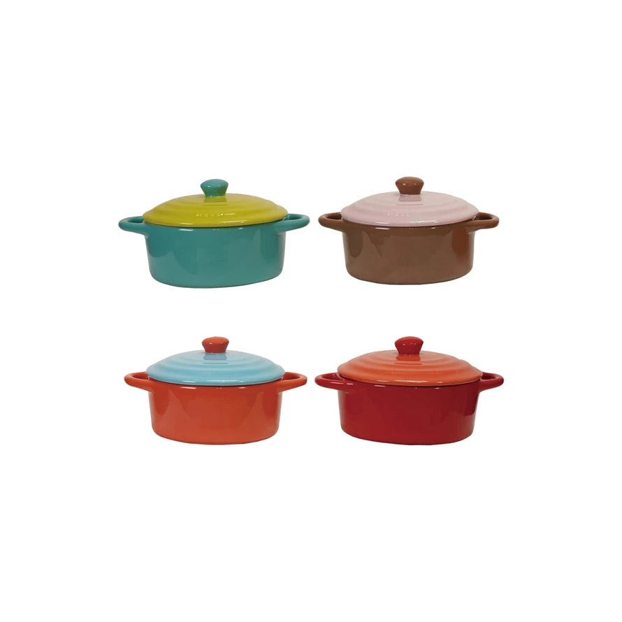Four colorful mini casserole dishes with lids on a white background