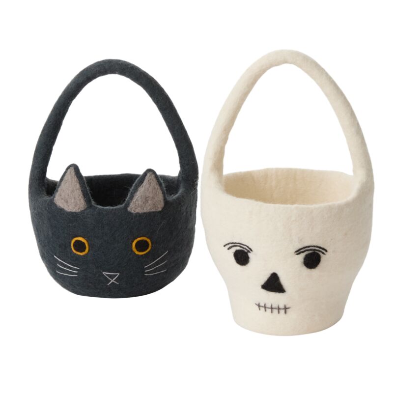 Two Halloween-themed baskets, one black with cat face design and one white with skull face design, on a white background.