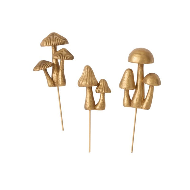 Two sets of gold mushroom-shaped skewers on a white background